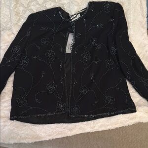 Sophisticated and dressy black coat. Floral sequin design.